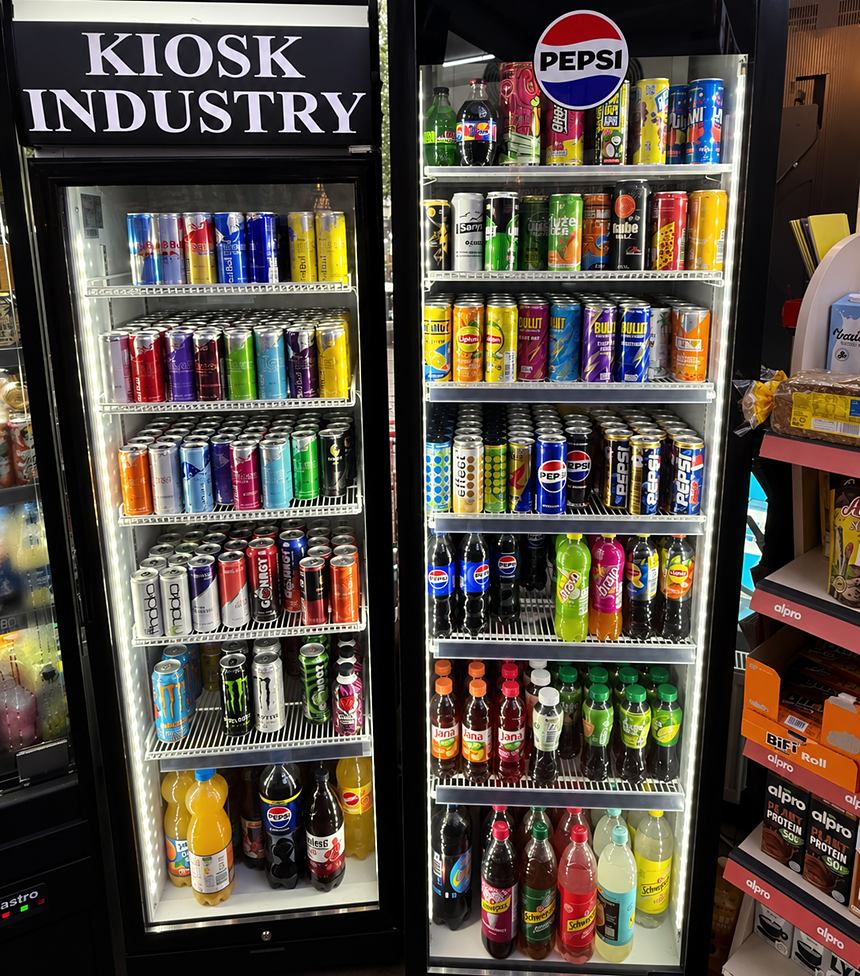 Zwei beleuchtete Kühlschränke im Kiosk: links mit KIOSK-INDUSTRY-Schriftzug und Energydrinks, rechts Softdrinks.